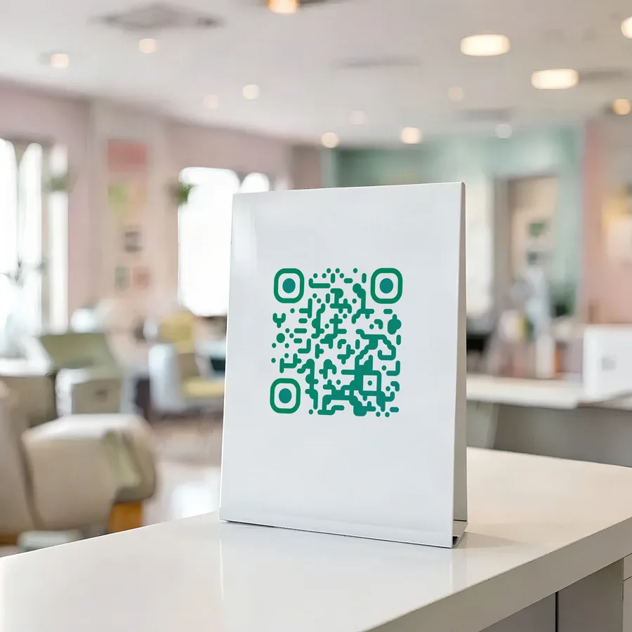 A QR code printed on a counter sign on a clinic reception desk.
